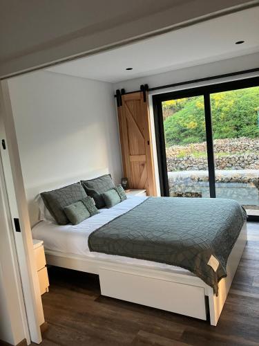a bedroom with a bed and a large window at Casa da Vinha Escondida AL in Biscoitos