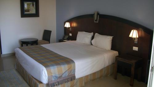 a bedroom with a large bed with a wooden headboard at Stella Di Mare Beach Hotel & Spa in Sharm El Sheikh