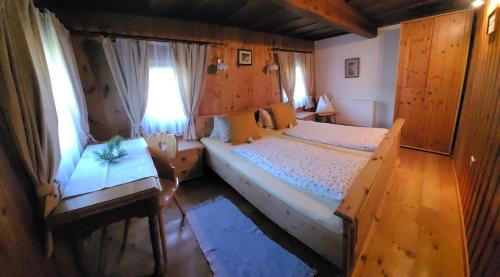 a bedroom with two beds and a table and a window at Fuggerhütte in Flattnitz