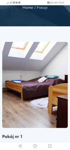 a bedroom with two beds in a room with skylights at DOM WESELNY 'DWÓR W JUROWCACH' in Sanok