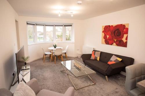 ein Wohnzimmer mit Sofa und Tisch in der Unterkunft Panorama House, Modern 3-Bedroom Apartment 3, Oxford in Kidlington