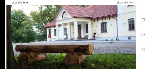 a log bench in front of a house at DOM WESELNY 'DWÓR W JUROWCACH' in Sanok