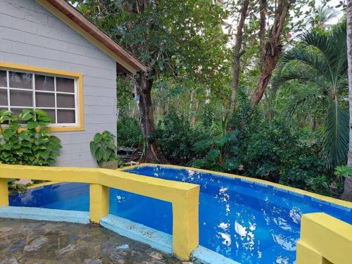 um banco amarelo sentado ao lado de uma piscina azul em La casita de la playa em La Entrada
