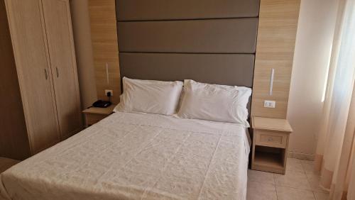 a bedroom with a bed with white sheets and pillows at Hotel Trasimeno Bittarelli in Castiglione del Lago