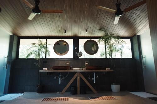 a bathroom with two sinks and two mirrors on the wall at LA SELVA Resort, Pench National Park in Khawāsa