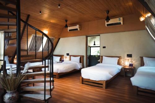 Khawāsa的住宿－LA SELVA Resort, Pench National Park，一间带两张床的卧室和螺旋楼梯
