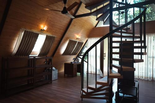 a spiral staircase in a room with wooden walls at LA SELVA Resort, Pench National Park in Khawāsa