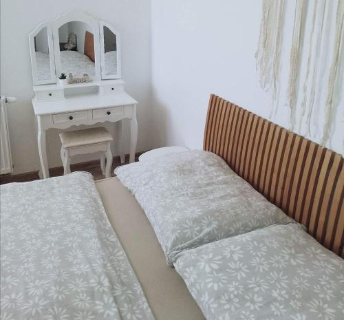 a bedroom with two beds and a desk with a mirror at Apartmány ZELENÝ DOM in Podhájska