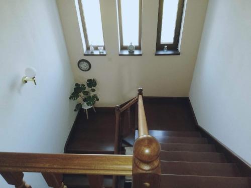 a stairwell with a wooden staircase with windows at Apartmány ZELENÝ DOM in Podhájska