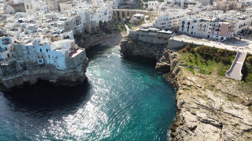 an aerial view of a city and the water at Polignano a Mare: sulla piazza di Domenico Modugno in Polignano a Mare