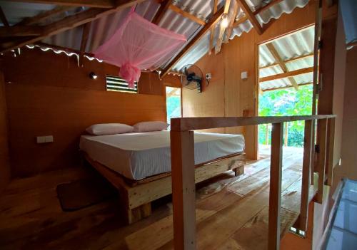 a bedroom with a bed with a pink umbrella at Sigiriya River Side Villa in Sigiriya