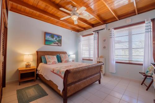 1 dormitorio con 1 cama y ventilador de techo en Coral Bay Villas en San Pedro