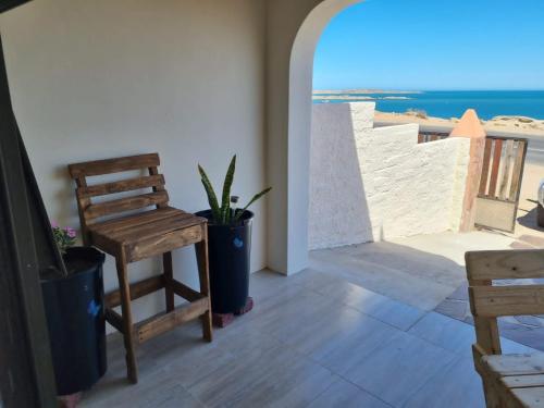 um quarto com uma cadeira e vista para a praia em Seabreeze Accommodation em Lüderitz