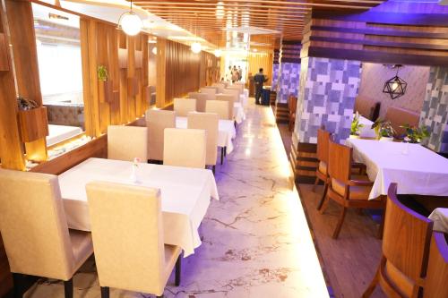a row of tables and chairs in a restaurant at Hotel EDEN in Kārwār