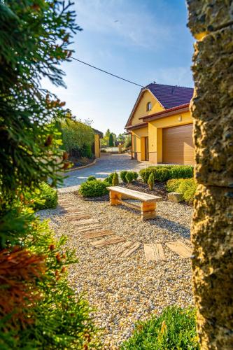 a stone walkway with a bench in a yard at Luxusní vila v Rudici in Rudice