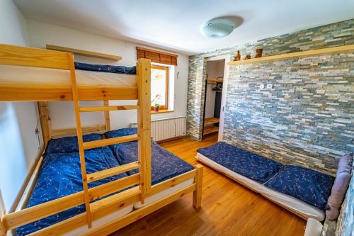 a room with two bunk beds and a brick wall at Luxusní vila v Rudici in Rudice