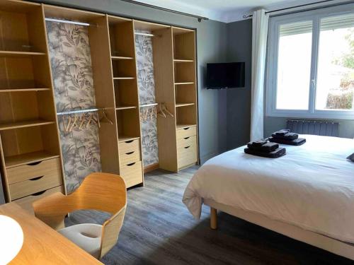 a bedroom with a bed and shelves and a window at Maison climatisée avec stationnement et wifi in Bram