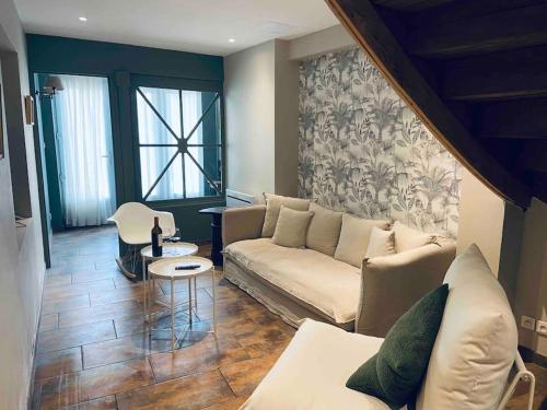 a living room with a couch and a table at Maison climatisée avec stationnement et wifi in Bram
