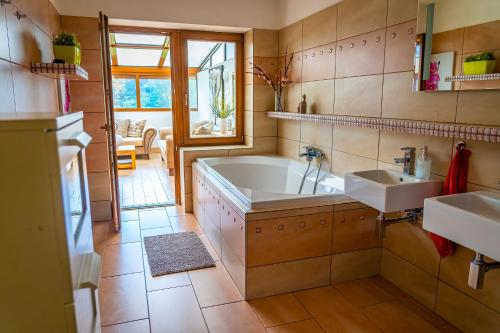 a bathroom with a tub and two sinks at Luxusní vila v Rudici in Rudice