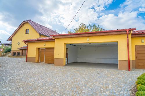 a house with a garage with a driveway at Luxusní vila v Rudici in Rudice
