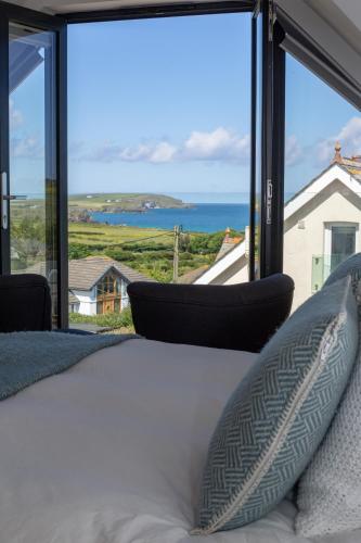 a bedroom with a bed and a view of the ocean at St Helen’s House in Padstow