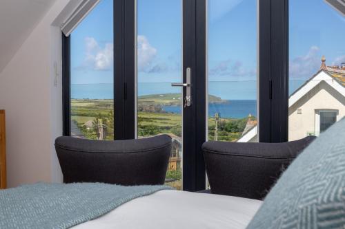 1 dormitorio con cama y vistas al océano en St Helen’s House, en Padstow