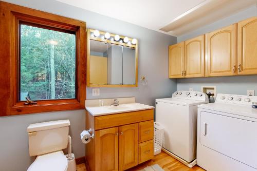 een badkamer met een toilet, een wasmachine en een droger bij Coolidge Drive Retreat in Quechee