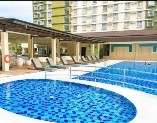 een groot zwembad met stoelen en een gebouw bij Bamboo Bay Condominium T1 in Nawanao