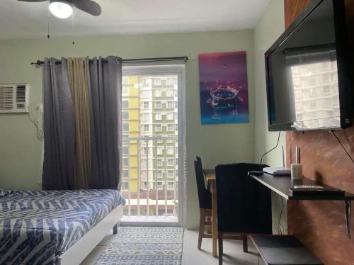 een slaapkamer met een bed, een bureau en een raam bij Bamboo Bay Condominium T1 in Nawanao