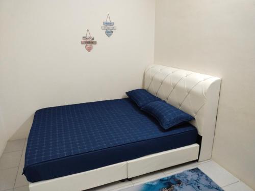 un letto in una camera con materasso blu di WAFID HOMESTAY SERI ISKANDAR a Seri Iskandar