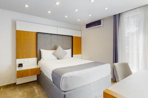 1 dormitorio con 1 cama blanca grande y escritorio en Seven Boutique 10, en Cancún