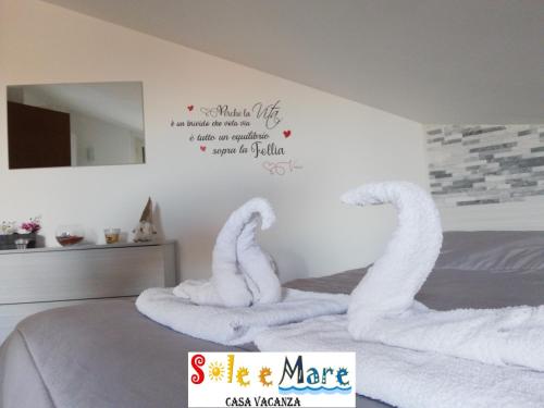 un dormitorio con cisnes hechos de toallas en una cama en SOLE e MARE Luxury Home, en San Salvo