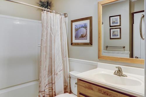 ein Badezimmer mit einem Waschbecken, einem WC und einem Spiegel in der Unterkunft Sea Side Villas 163 in Hilton Head Island