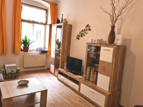 uma sala de estar com uma televisão e uma mesa em FeWo-Regenbogen-Dresden em Dresden