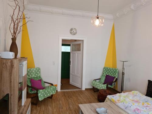 uma sala de estar com duas cadeiras e uma cama em FeWo-Regenbogen-Dresden em Dresden