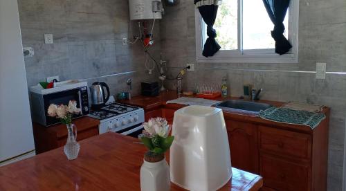 una cocina con una mesa con flores en un jarrón en Apartamento Varetto en Sierra de los Padres