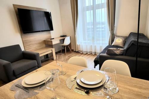 a living room with a table with plates and wine glasses at Modern Silver Apartment 2 rooms Bosacka Old Town in Krakow
