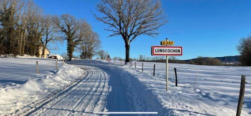 Una carretera cubierta de nieve con un cartel que dice evacuación en Le gite de Longcochon, en Longcochon