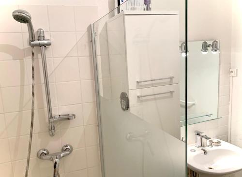 una ducha con una puerta de cristal junto a un lavabo en Jolie chambre Marseille centre, en Marsella