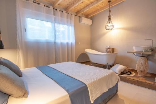 a bedroom with a bed and a tub and a sink at Georgianna's suite with private pool , 'blank suite' in Kharokopión