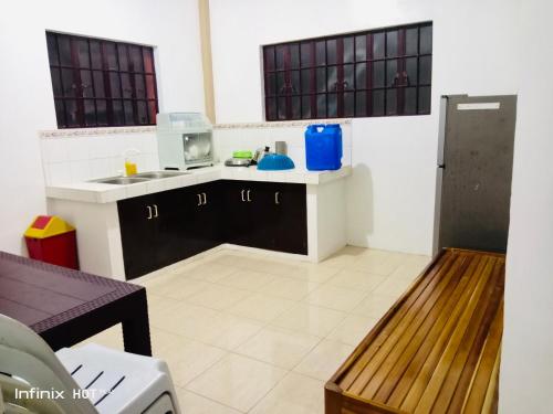 a kitchen with a sink and a microwave at Estrelle Orange House - Backpackers Hub in Puerto Princesa City