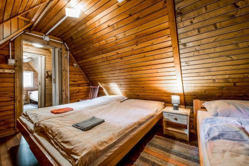 1 dormitorio con 1 cama en una pared de madera en Old Fashioned Cottage in Lopusna dolina near High Tatras, en Lučivná