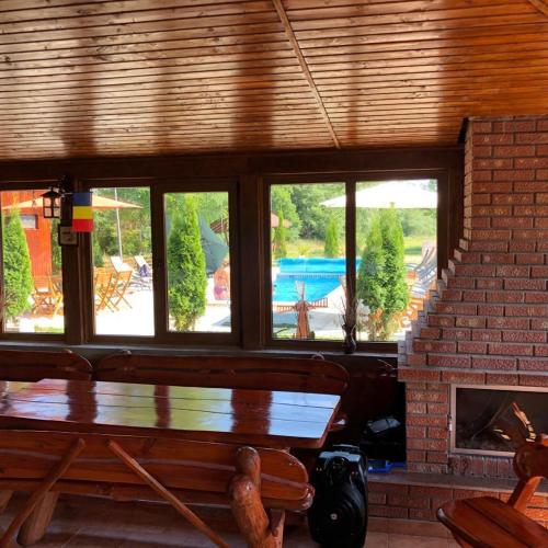 a living room with a table and a fireplace at Dorul Pescarului in Curtea de Argeş