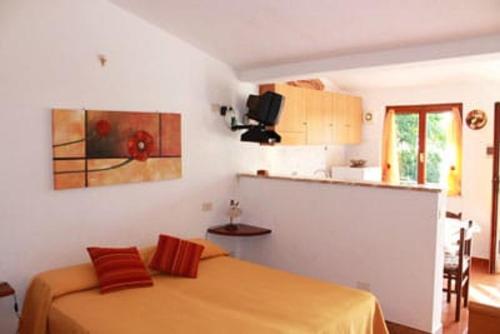 a small bedroom with a bed and a kitchen at Fewo Sole e Azzurro in Capoliveri