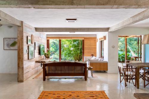 ein Wohnzimmer mit einer Bank und einem Tisch in der Unterkunft Casa Laranjeiras, Rio da Barra beach, Trancoso in Trancoso