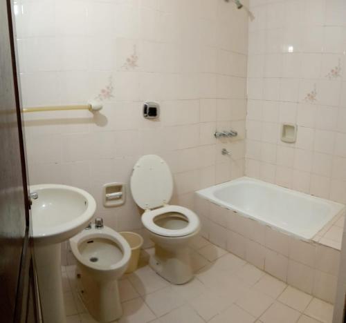 a bathroom with a toilet and a tub and a sink at HOTEL FERMOZA in Formosa