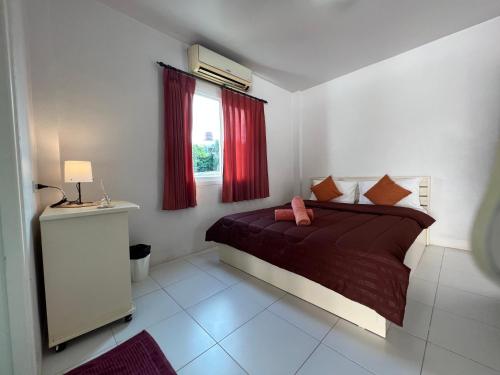 卡塔海灘的住宿－The 4 Blocks at Kata noi，一间卧室配有一张带红色窗帘的床和一扇窗户