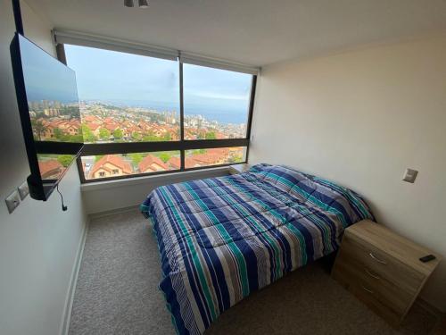 a bedroom with a bed and a large window at ALTO DE VIÑA PARQUE MARAÑON VIÑA DEL MAR in Viña del Mar