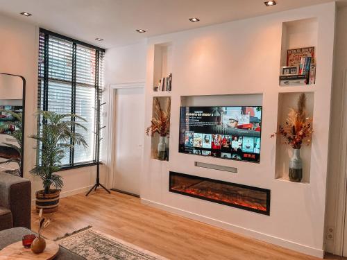 un soggiorno con camino e TV a schermo piatto di Coolest Apartment in Haarlem City - close to Beach and Amsterdam a Haarlem