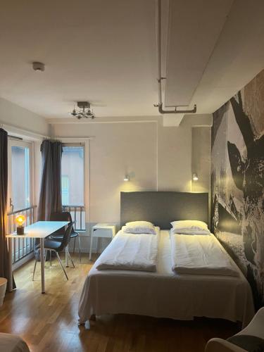 a bedroom with a bed and a table and a dining room at City Hostel Bergen in Bergen